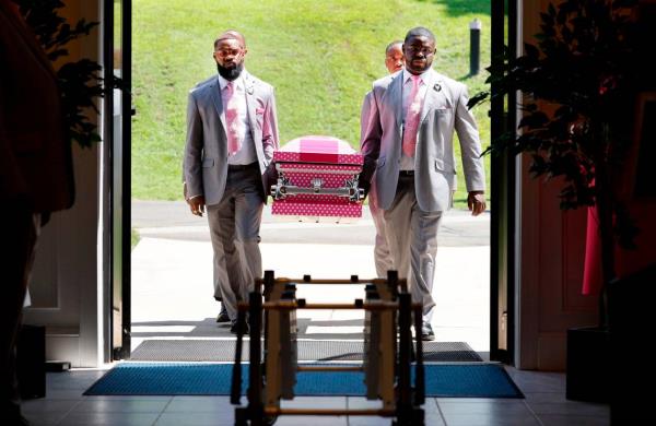 Christopher Weaver, left, Curtis Peaks, right, along with Michael Kithcart and Kamal Simpson with Weaver & Peaks Funeral Care bring the casket of five-year-old Khloe Fennell into Immanuel Temple Church before her funeral in Durham, N.C., Friday, July 21, 2023. Fennell was killed by gunfire on July 5th.